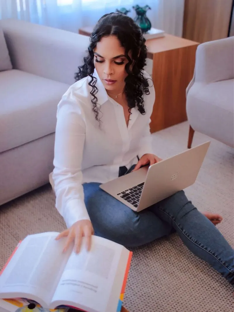 Fernanda Pinha sentada no chão com o notebook, estudando